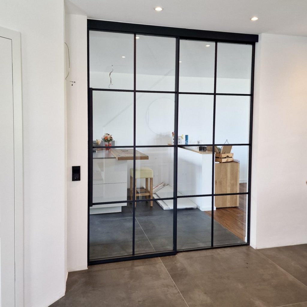 Entdecken Sie den Charme urbaner Eleganz mit unserem Loft-Raumteiler: Ausgestattet mit Schiebetür, verbindet dieser stilvolle Raumteiler Funktionalität mit modernem Design.