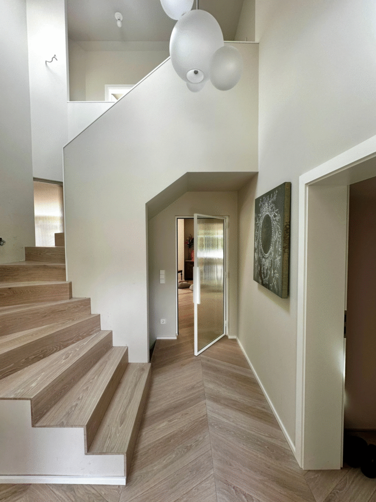 Weiße Loft-Drehtür mit Visiosun-Glas zwischen Eingangsbereich und Wohnraum