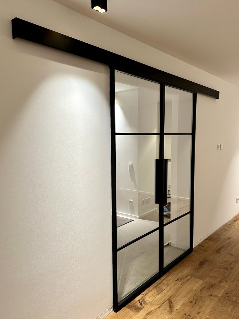 Doppelte Loft-Schiebetür mit Klarglas zwischen Wohnraum und Treppenhaus