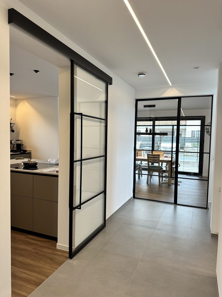 Loft-Schiebetür im Polo4-Design mit schwarzem Rahmen zur Küche