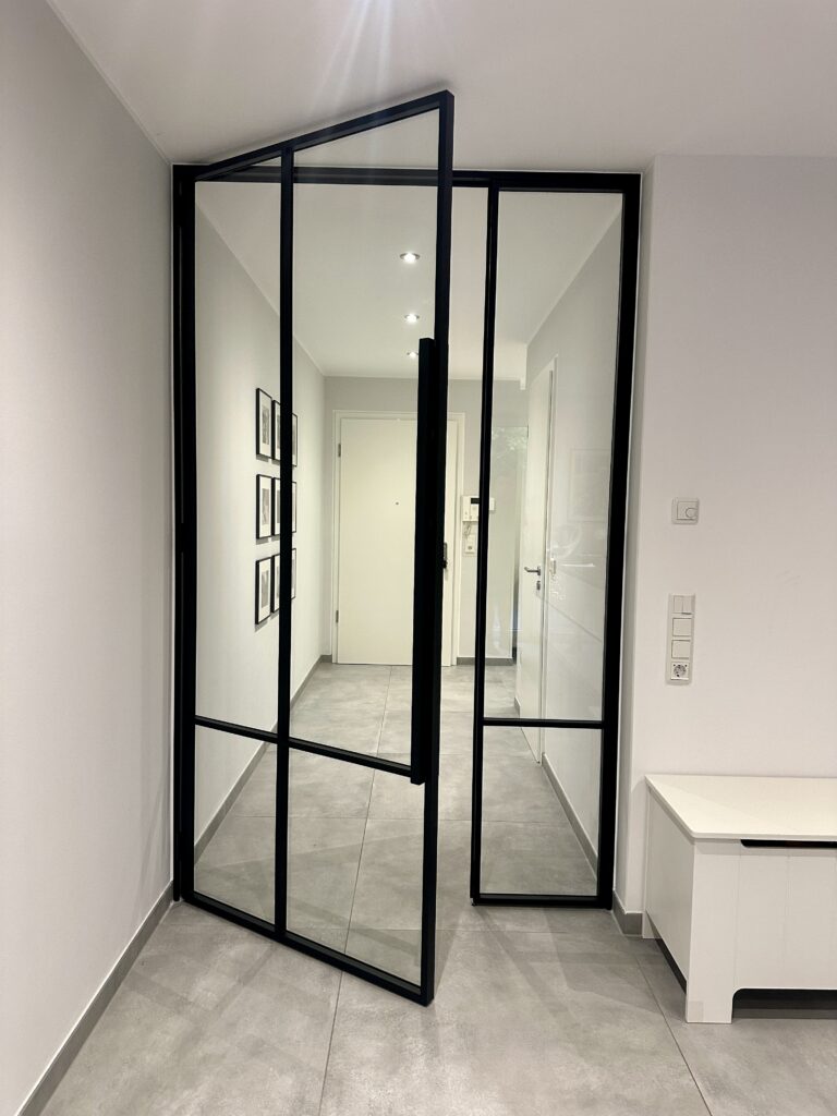 Klassische Loft-Drehtür mit Seitenteil im Windfang aus schwarzem Stahl RAL 9005 und Klarglas im Design CROSS