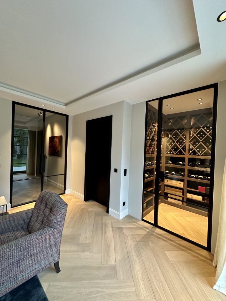 Lofttür aus schwarzem Stahl mit Glas als Innentür zwischen Wohnzimmer und Weinkeller