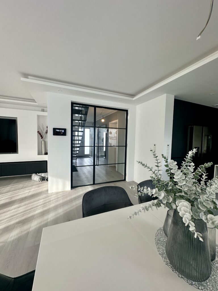 Windfang mit Lofttür im modernen Einfamilienhaus zwischen Eingangsbereich und Treppe